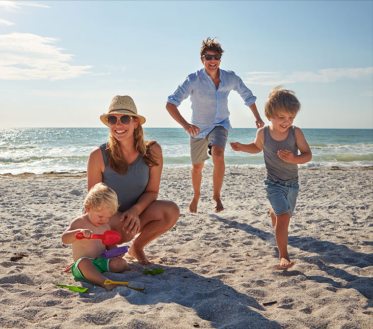 Junge Familie spielt gemeinsam am Strand