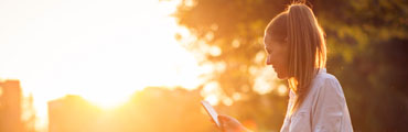 Junge Frau im Park prüft CO2-Fußabdruck in ihrer Handy-App