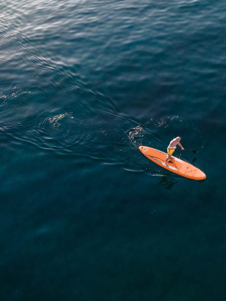 Mann auf einem Surfboard alleine im Meer